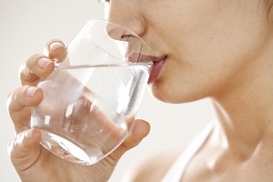 Young woman drinking glass of water - Atlanta Institute for ENT