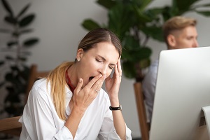 Bored tired businesswoman yawning at workplace - Atlanta Institute for ENT